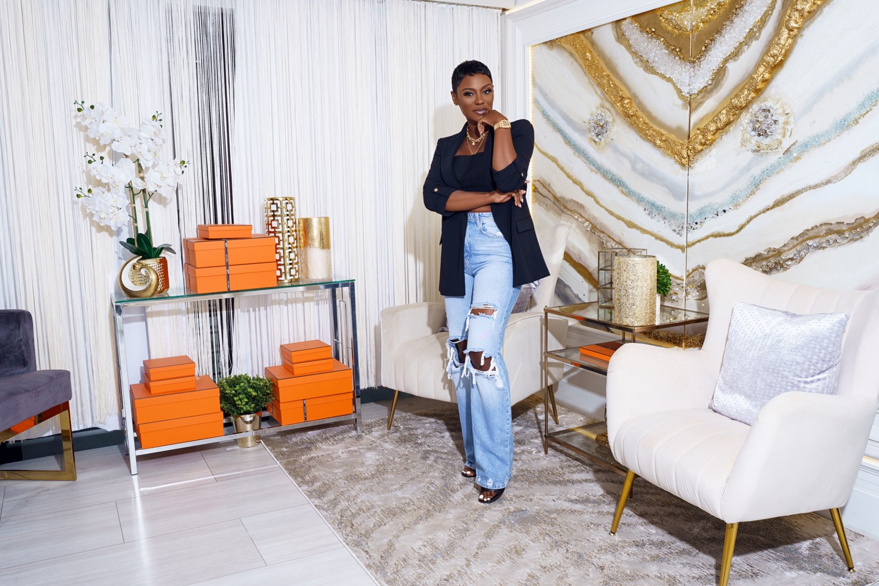 Mela standing in an elegant ivory and gold interior
